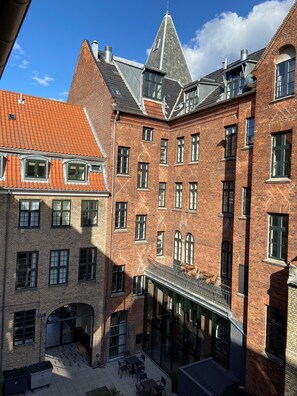 A courtyard with a brick building featuring multiple windows and a sloped roof. - Hotel Bethel (Copenhagen)