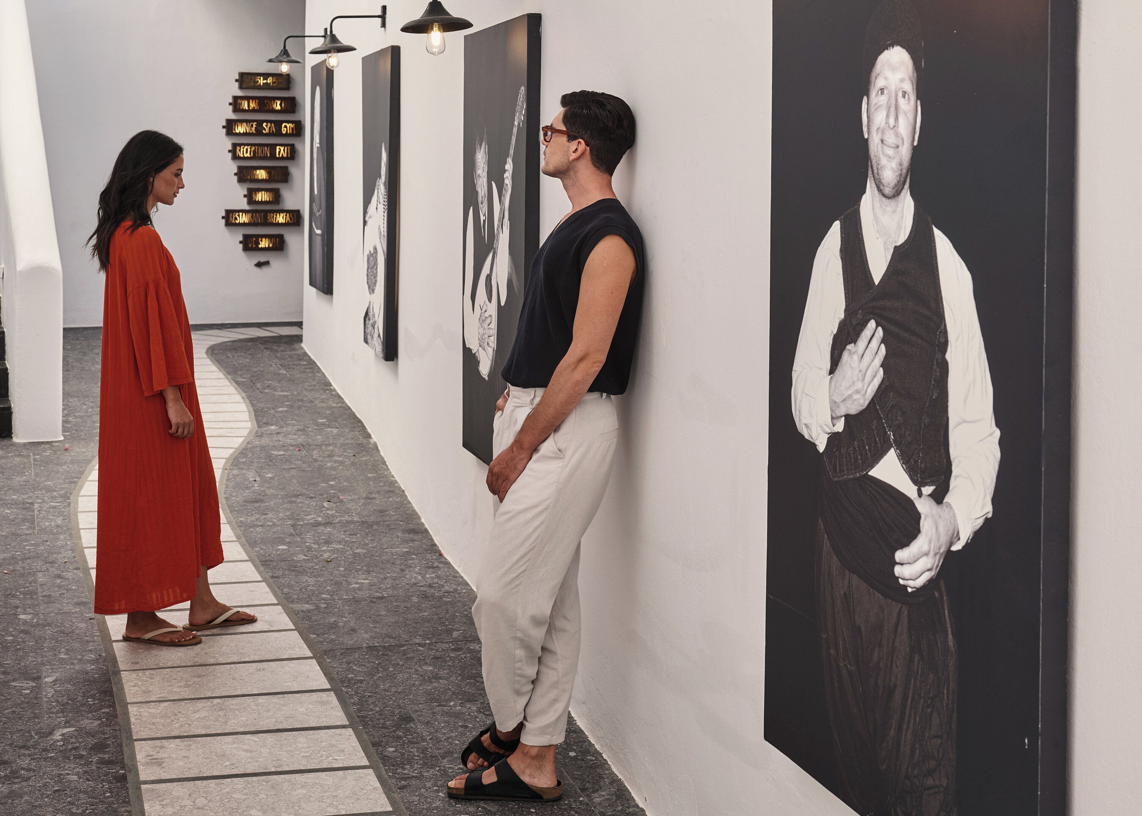 A corridor with art installations and directional signs.