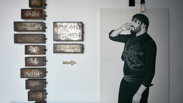 A wall with metal signs indicating various locations such as 'EXIT', 'RECEPTION', 'SWIMMING POOL', 'SNACK BAR', 'WC SHOWER', 'BOUTIQUE', and 'LOUNGE'.