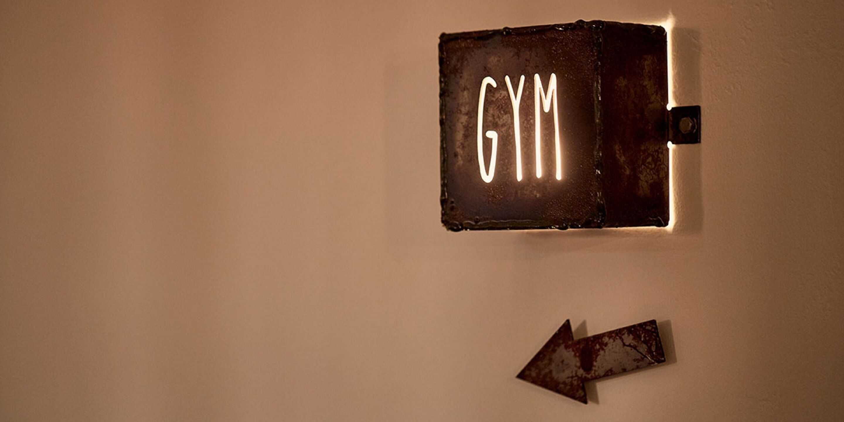 A wall-mounted sign with the word "GYM" and an arrow pointing to the right.
