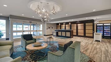 A lobby with seating, a reception desk, and a refrigerator.
