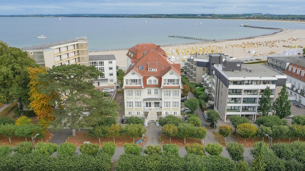 Ein Hotel mit Innenhof, umgeben von Bäumen und Blick auf den Strand.