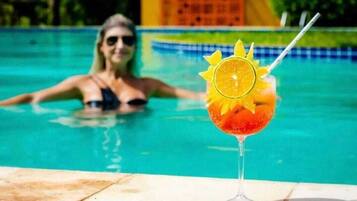 Una piscina al aire libre, sillones reclinables de piscina