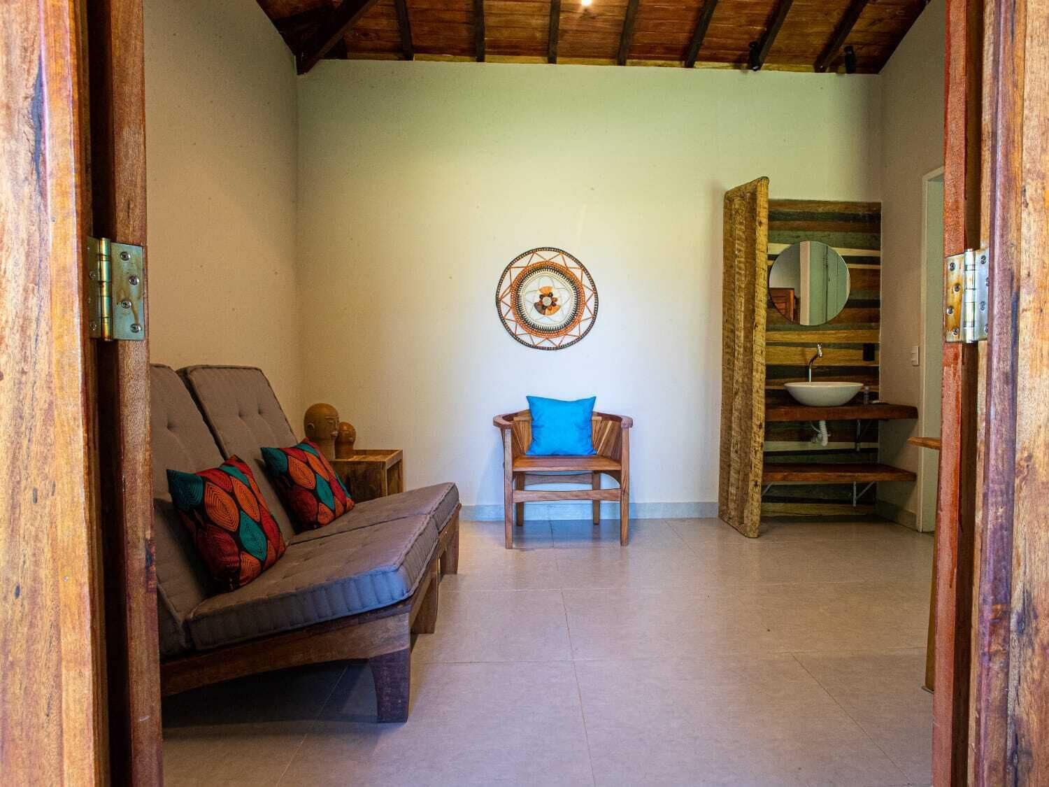 A cozy room with a wooden bench, a small table, and a wall-mounted circular decoration.
