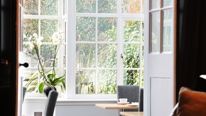 A cozy room with a large window, a comfortable sofa, a small table, and a chair. - 94DR (Edinburgh)