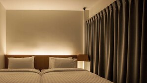 Un lit double avec une tête de lit, deux oreillers et une lampe de chevet.