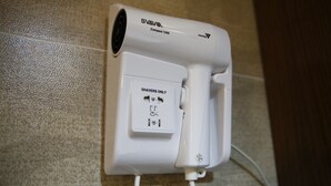 A white portable shaver charging station with a compact 1300 model, a power outlet, and a USB port. - Sandhu guest house (Kowloon)