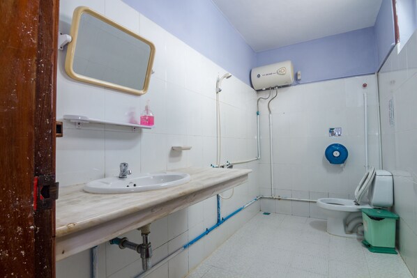 A bathroom with a sink, mirror, toilet, and shower. - Lovely Jubbly Villa - Hostel (Phnom Penh)