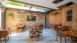 A restaurant with brick walls, wooden tables and chairs, and a large window overlooking greenery. - Blisstanbul Hotel (Istanbul)
