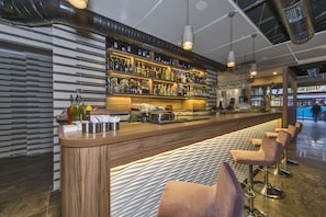 A bar area with a long counter, multiple shelves of bottles, and bar stools. - Blisstanbul Hotel (Istanbul)