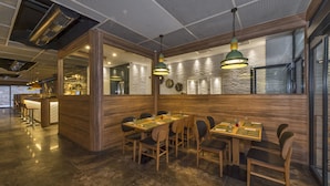 A restaurant with wooden tables and chairs, a bar area, and a modern ceiling design. - Blisstanbul Hotel (Istanbul)