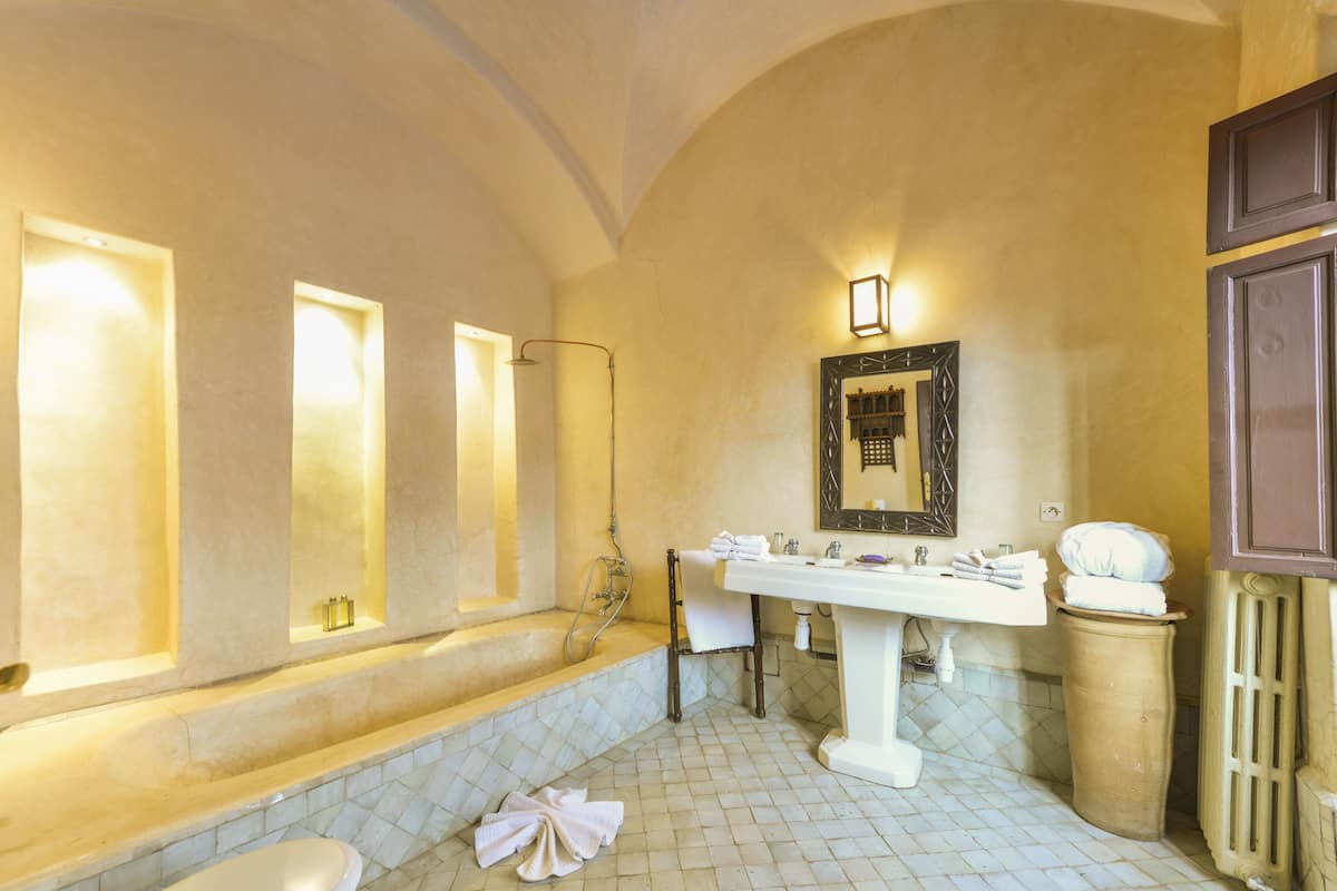 A bathroom with a bathtub, a sink, and a mirror.