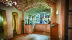 A bar area with a brick ceiling, wooden cabinets, and a display of bottles. - Hôtel Riad Caravan Serai (Marrakech)