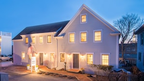 A two-story house with a front porch, a garage, and a driveway. - 8 Dyer Hotel (Provincetown)