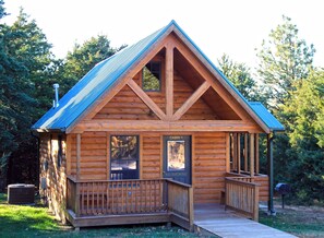 A cabin with a sloped roof, a porch with railings, and a 'No Smoking' sign.