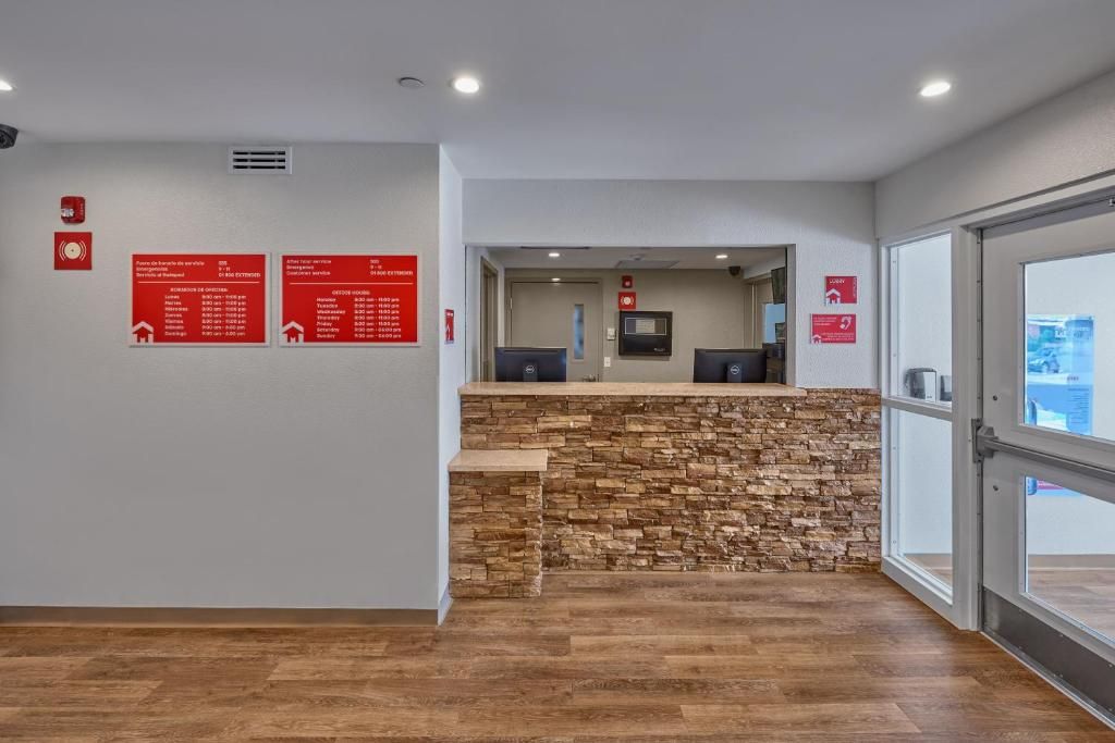 A reception area with a stone counter, a fire alarm, and informational signs on the wall.