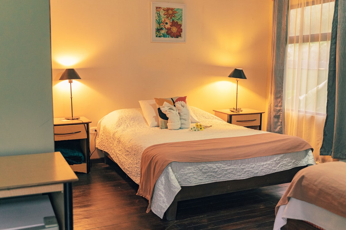 A neatly arranged bedroom with a bed, bedside tables, and lamps.