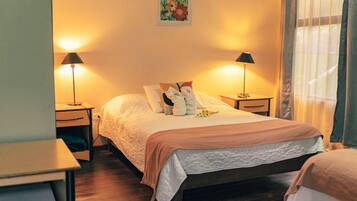 Un dormitorio ordenado con cama, mesitas de noche y lámparas.