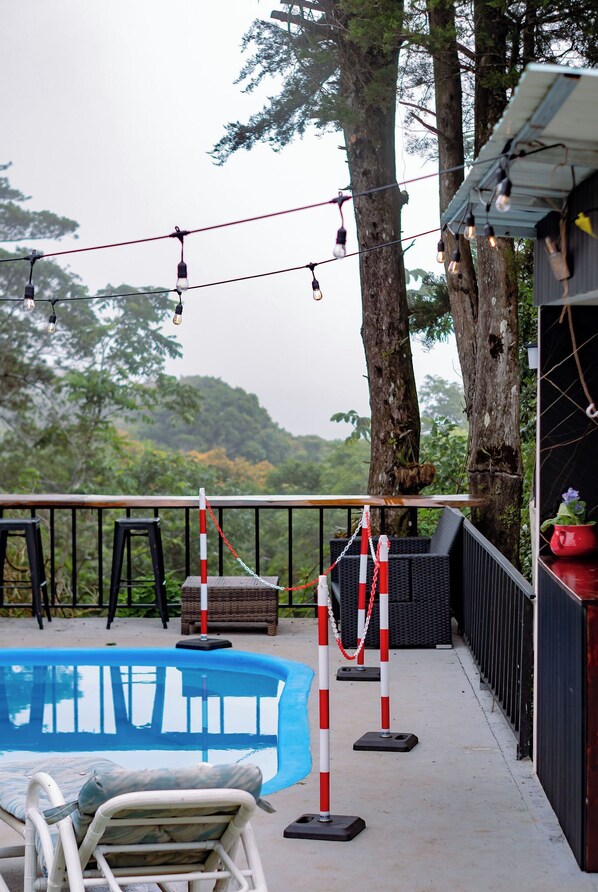 Un área junto a la piscina con tumbonas e iluminación decorativa.