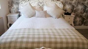 A bed with a checkered bedspread and a decorative headboard.