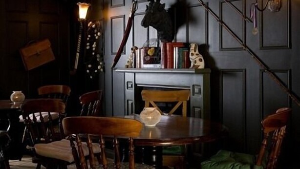 A dining area with a round table, chairs, a fireplace, and wall-mounted sconces. - The Lambton Worm (Chester-le-Street)