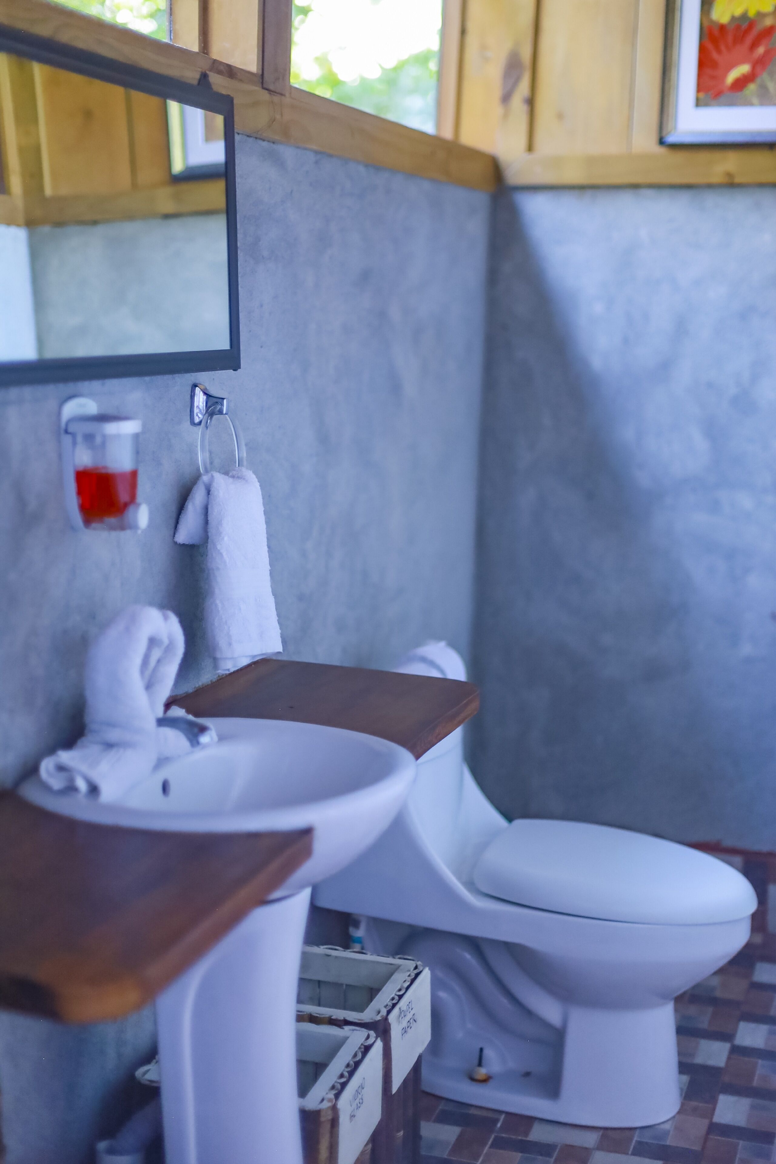 A bathroom with a white sink, a white toilet, and a mirror above the sink.