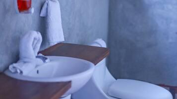 A bathroom with a white sink, a white toilet, and a mirror above the sink.