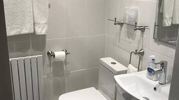 A modern bathroom with a toilet, sink, and shower.