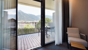 Ein Balkon mit Holzboden, einem Tisch und zwei Stühlen.