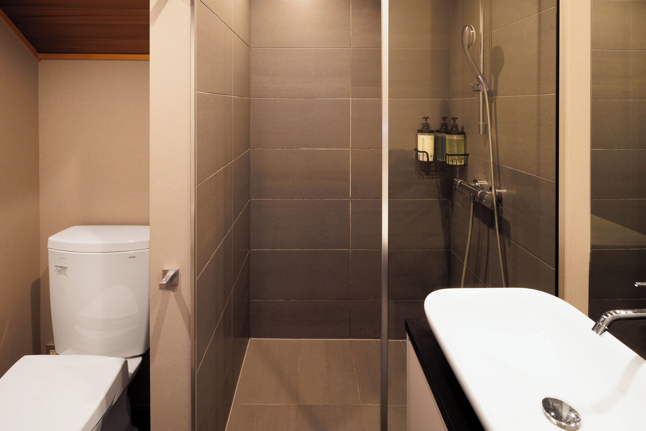 Un baño moderno con ducha, inodoro y lavamanos.
