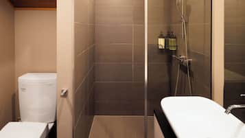 Un baño moderno con ducha, inodoro y lavamanos.