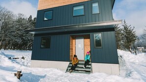 A modern two-story house with a wooden roof and a blue exterior. - Wagaya (Hakuba)