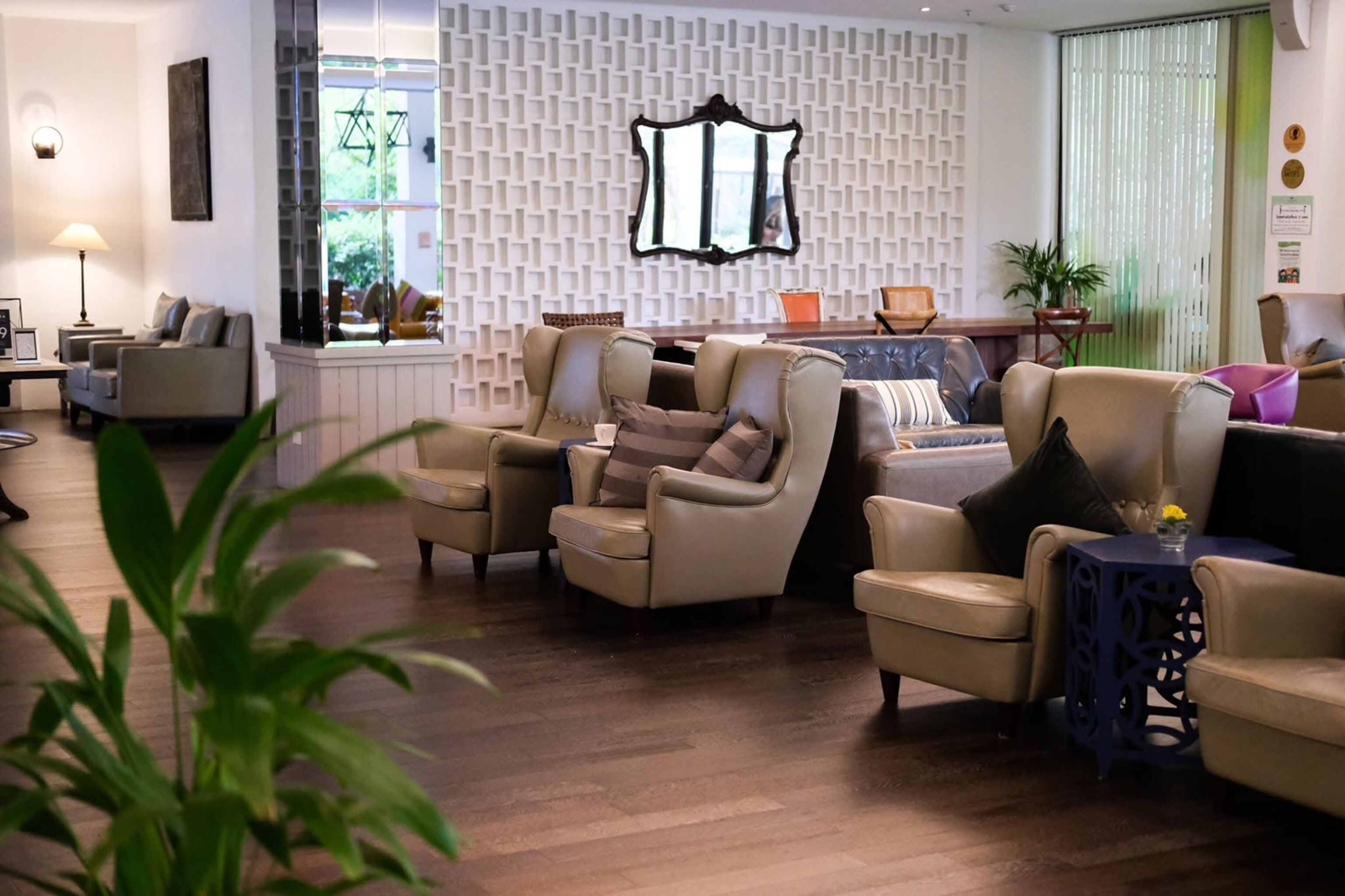 Un soggiorno moderno con divani in pelle, una parete decorata con motivi e uno specchio ornamentale.