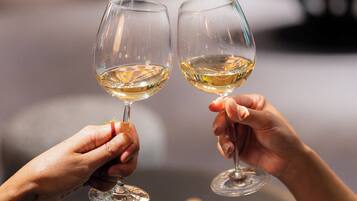 Two people holding wine glasses with a chessboard in the foreground.