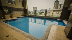An indoor swimming pool with a view of surrounding buildings. - Shaw Residenza Suites (Mandaluyong)