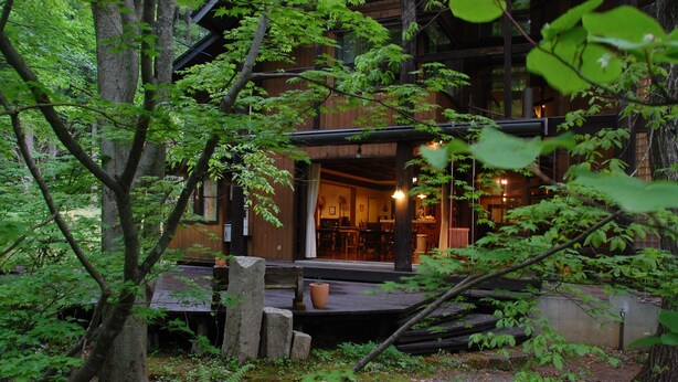 Eine rustikale Holzhütte mit Essbereich und sichtbarer Küche.