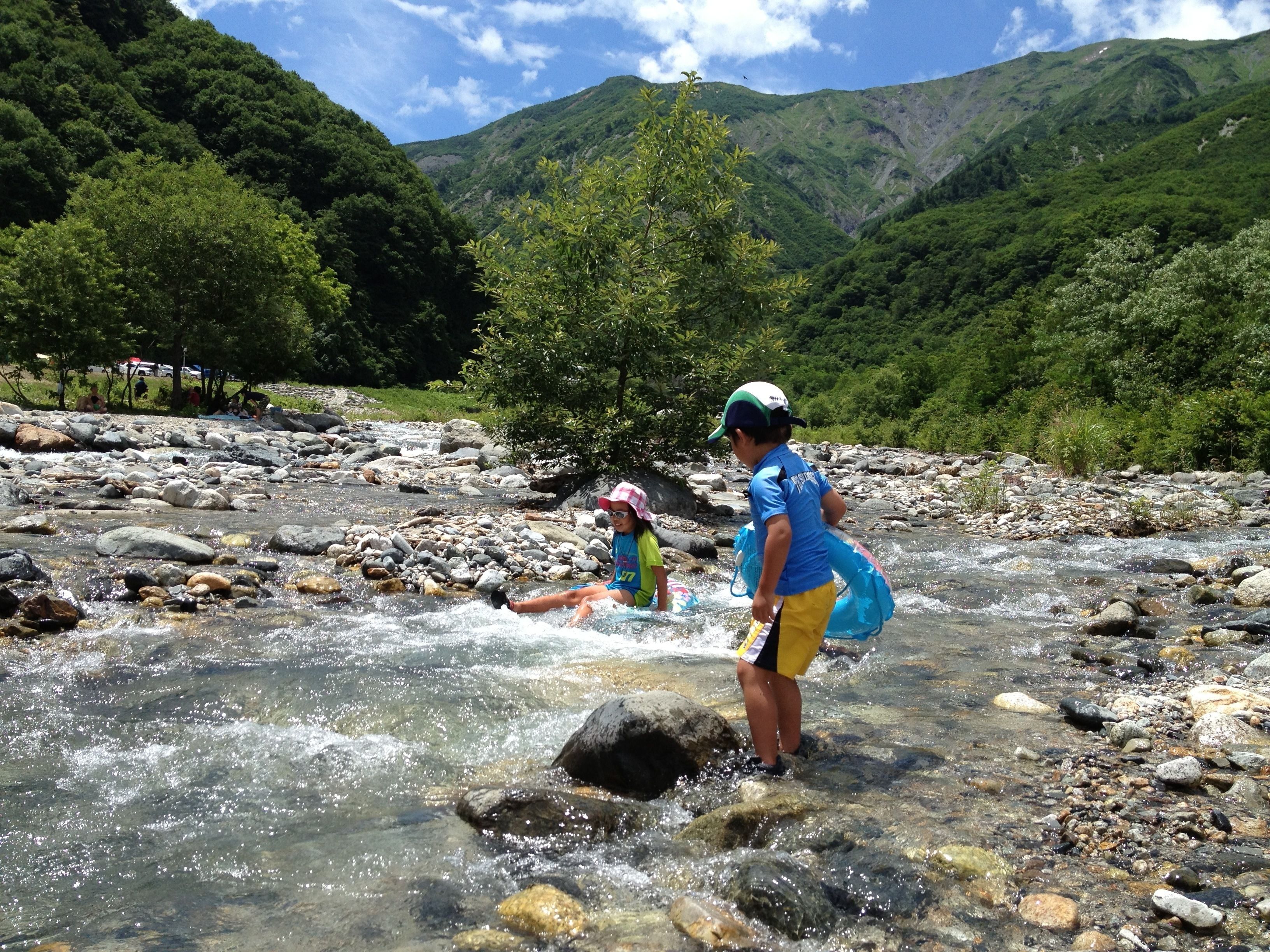 Un río con rocas y una persona de pie en el agua.