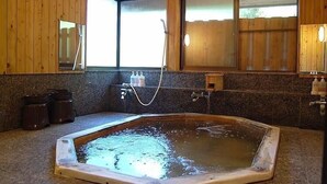 Innenansicht einer Holzhütte mit Whirlpool, Granit-Arbeitsplatten und einem großen Fenster.