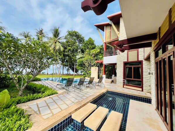 A pool area with lounge chairs and a view of the ocean. - Amatapura Beach Villa 12 (Krabi)