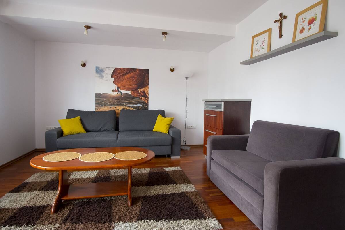 A living room with a sofa, a coffee table, and a painting on the wall.