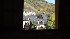 A view of buildings with multiple roofs and a hillside in the background.