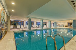 Una piscina techada, sillones reclinables de piscina