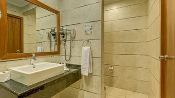 A bathroom with a sink, mirror, towel rack, and a hairdryer.