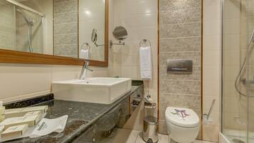 Une salle de bain moderne avec un lavabo, un miroir, des toilettes et une douche.