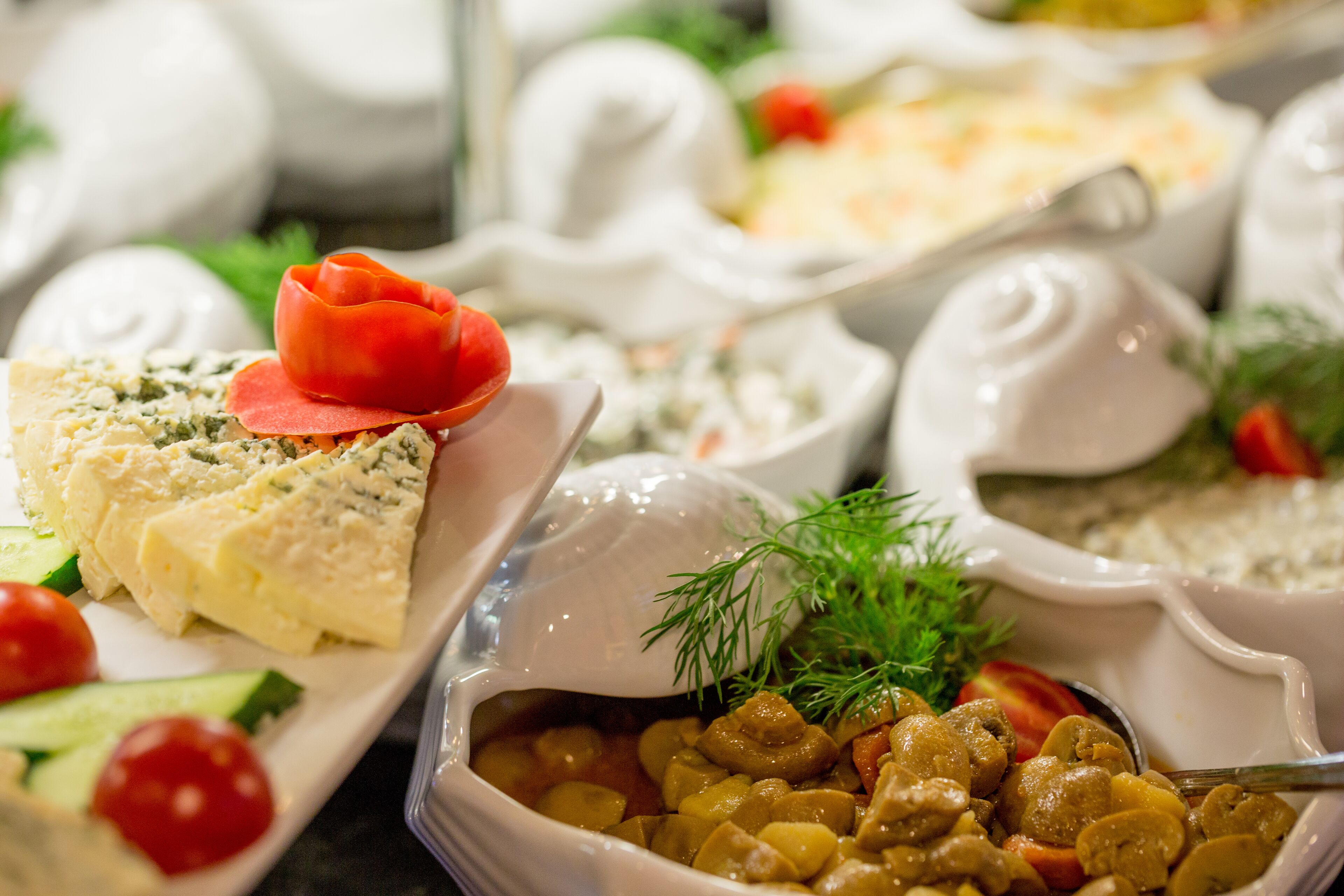 Diverse gerechten, waaronder een salade, een kom soep en een schotel met champignons en kruiden.