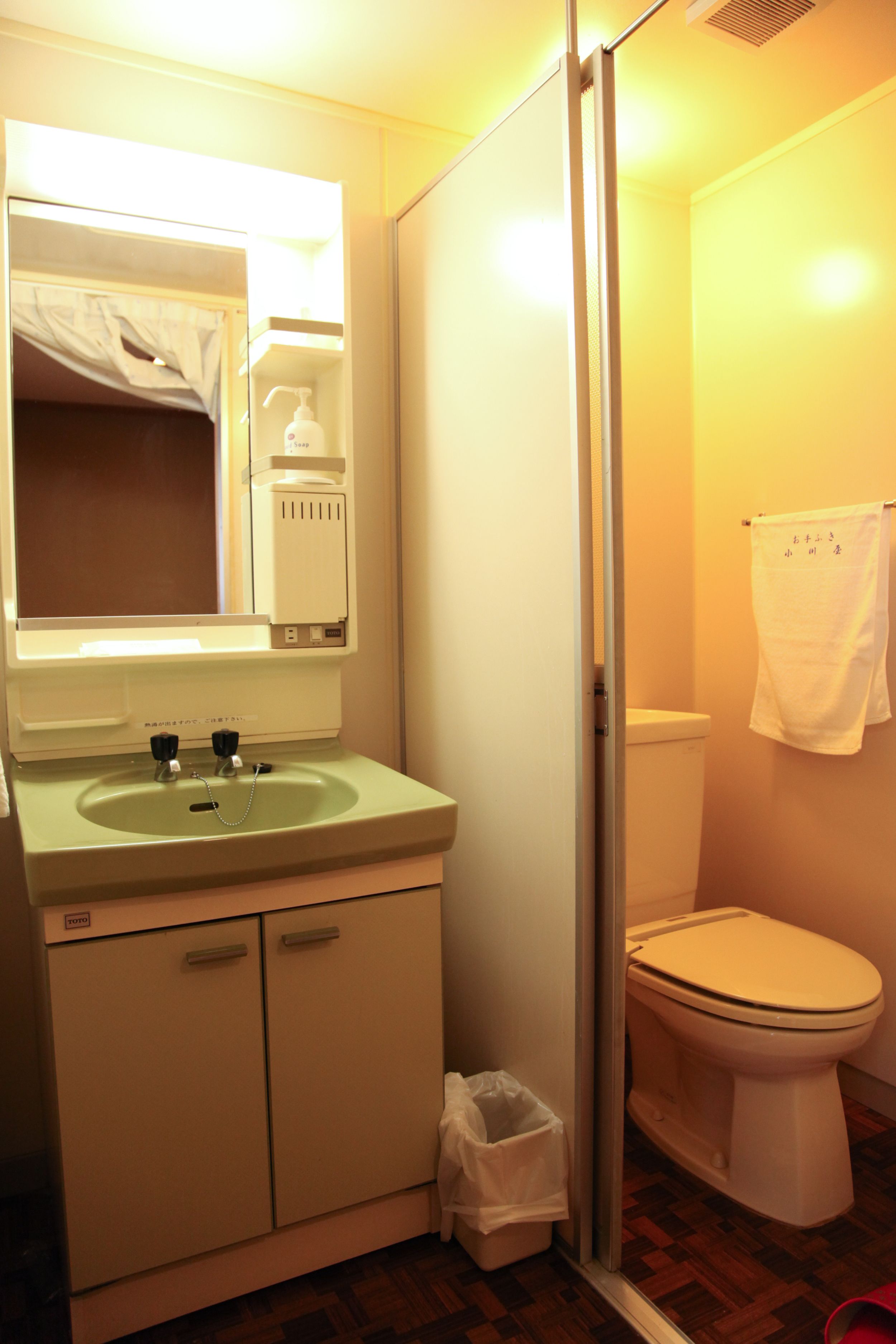 A bathroom with a sink, mirror, and toilet.