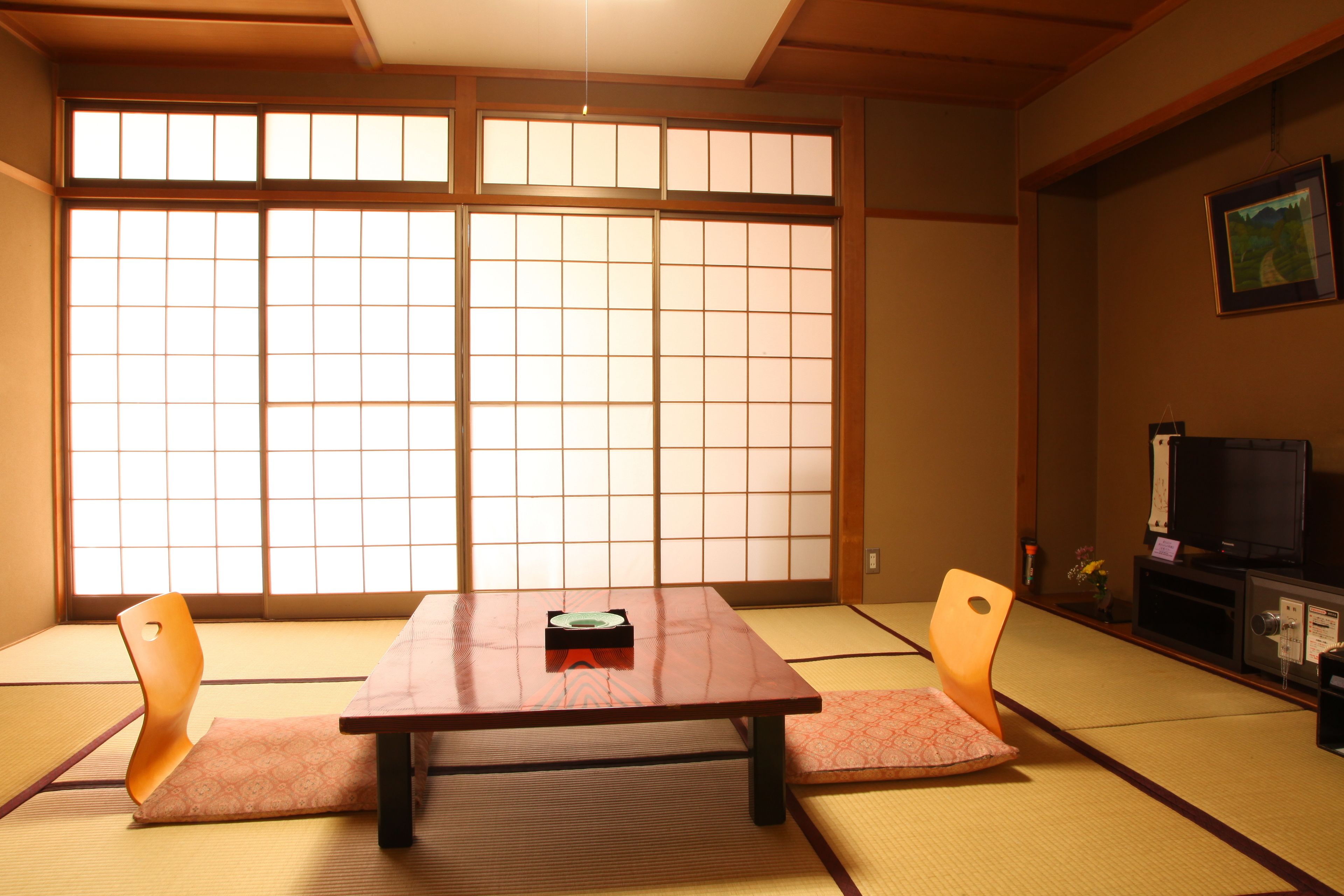 A traditional Japanese room with tatami flooring, a low wooden table, and sliding shoji doors.