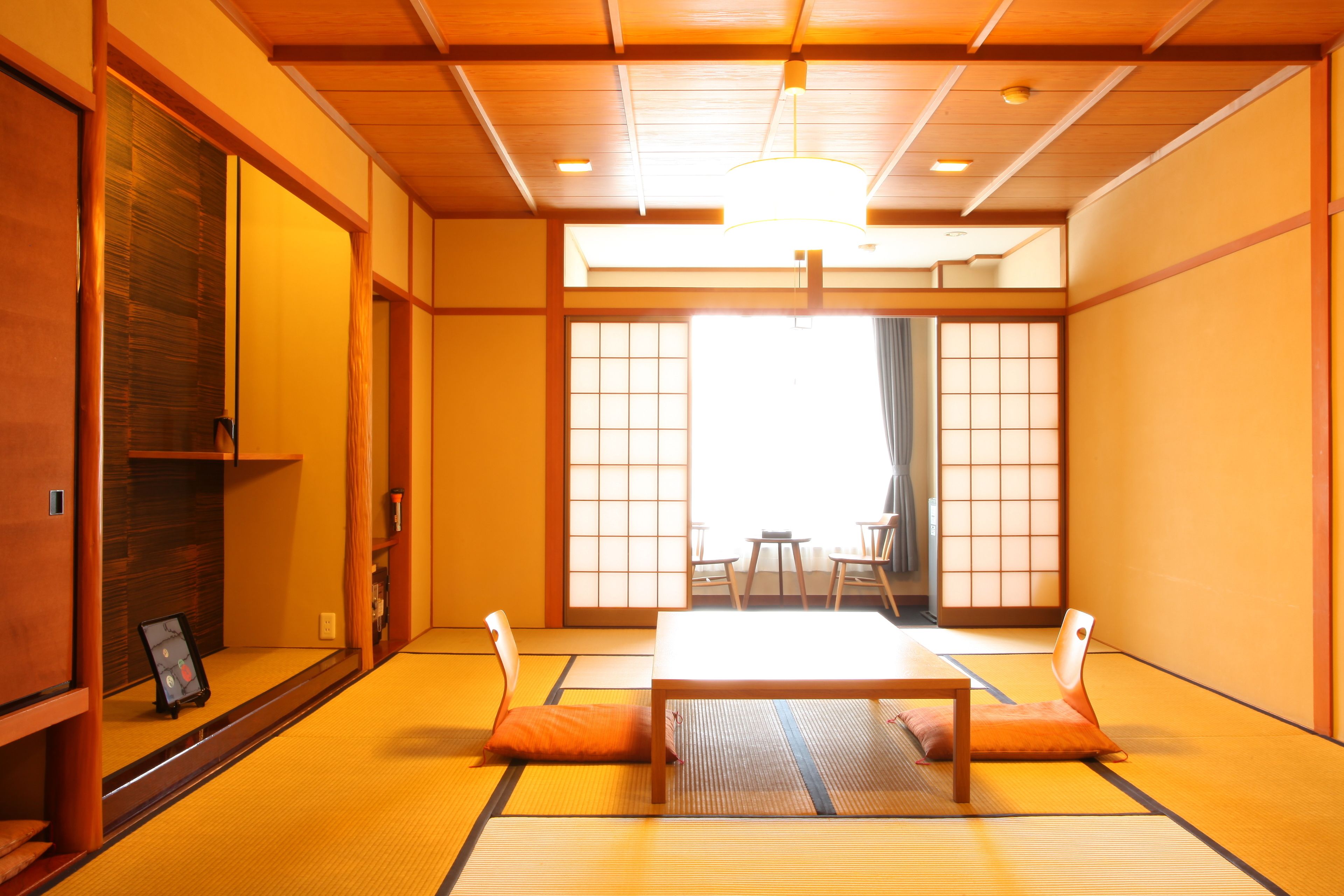 A traditional Japanese room with tatami flooring, a low table, and sliding doors.