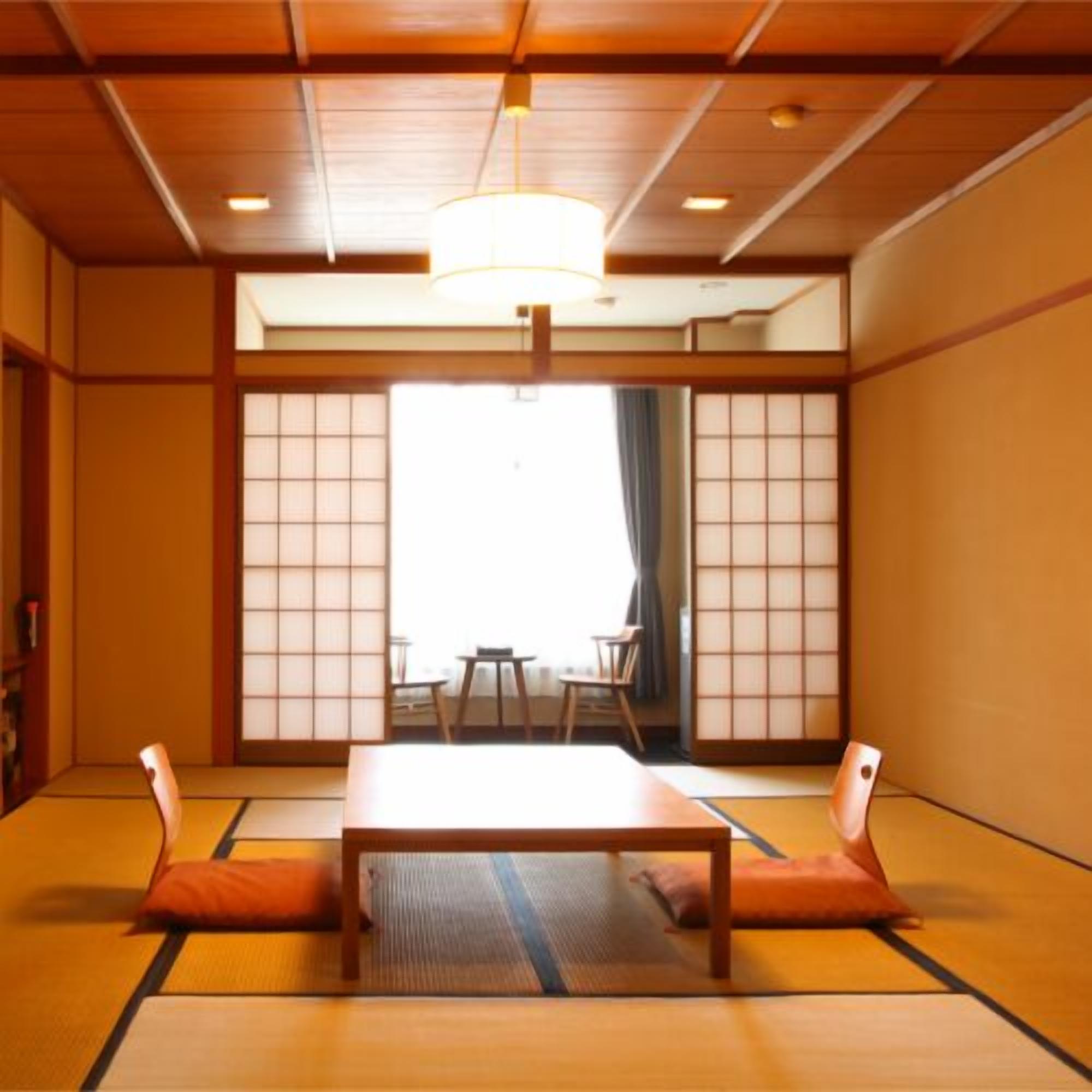 A traditional Japanese room with tatami flooring, a low table, and sliding doors.