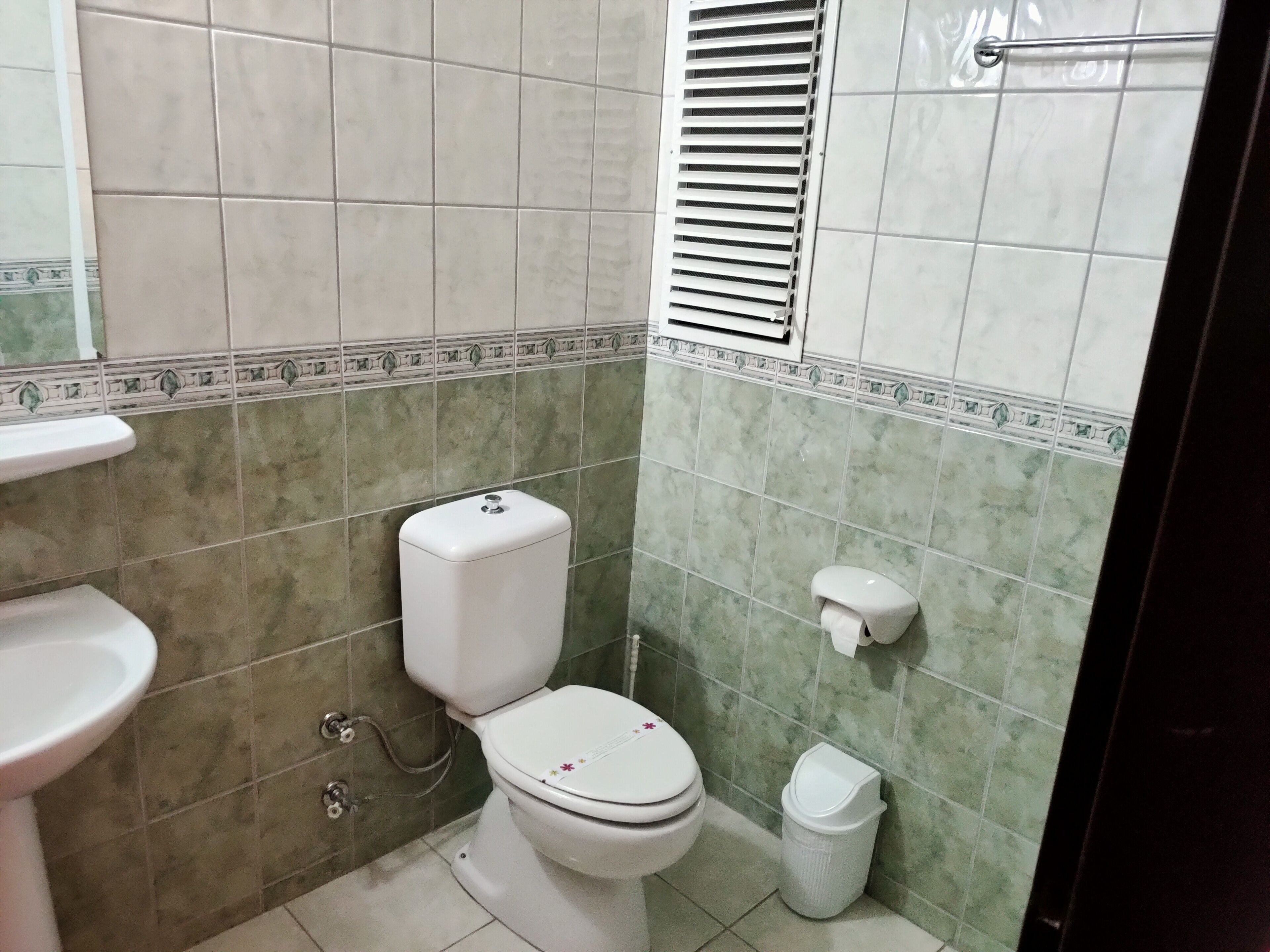 Ein kleines Badezimmer mit Toilette, Waschbecken und Dusche.